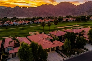 A residential area with houses, a golf course, and mountains in the background. - PGA west home with pool, gas grill spa and washer/dryer (La Quinta)