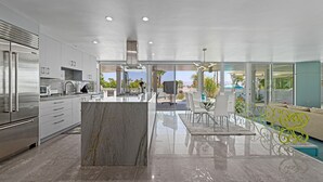 Una cocina moderna con electrodomésticos de acero inoxidable, una isla de mármol y vistas al exterior.