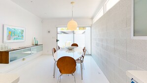 A modern dining area with a round table, chairs, and a pendant light. - Elegant Wexler home with private outdoor pool & spa - 2 dogs welcome (Palm Springs)