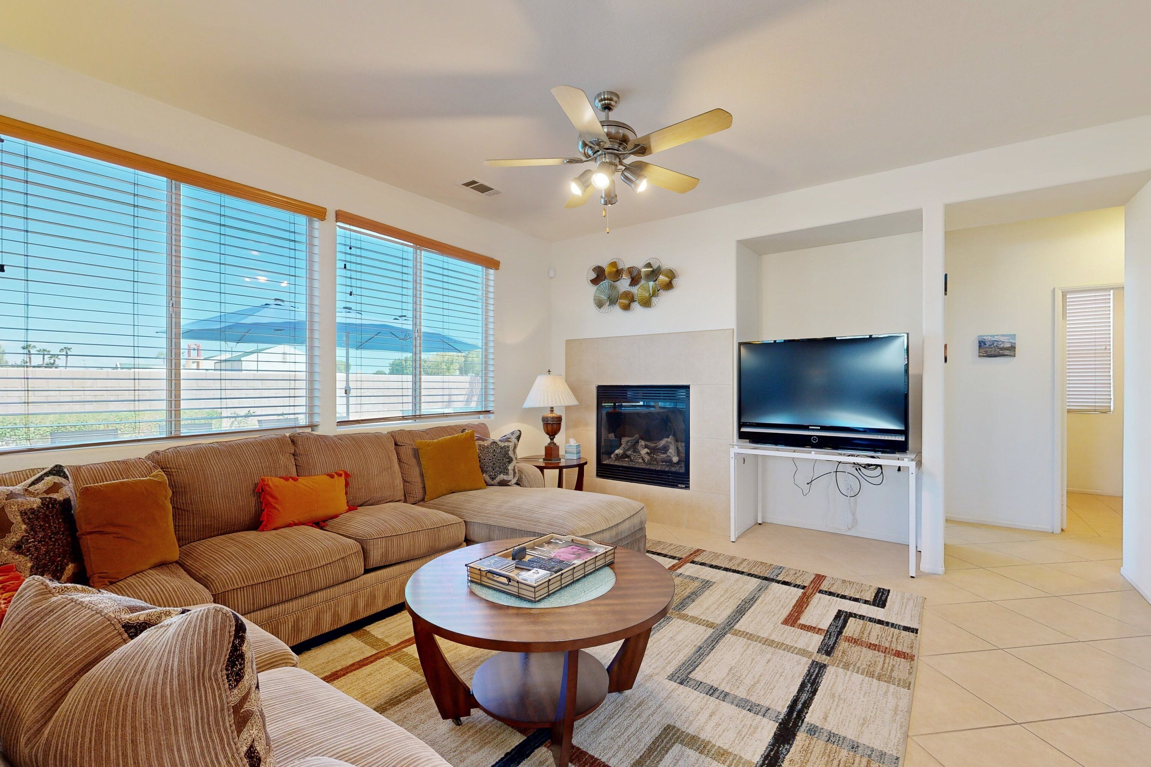 A living room with a sofa, a coffee table, a TV, and a fireplace.