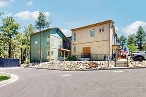 A two-story building with a gated driveway, a fire hydrant, and an American flag.