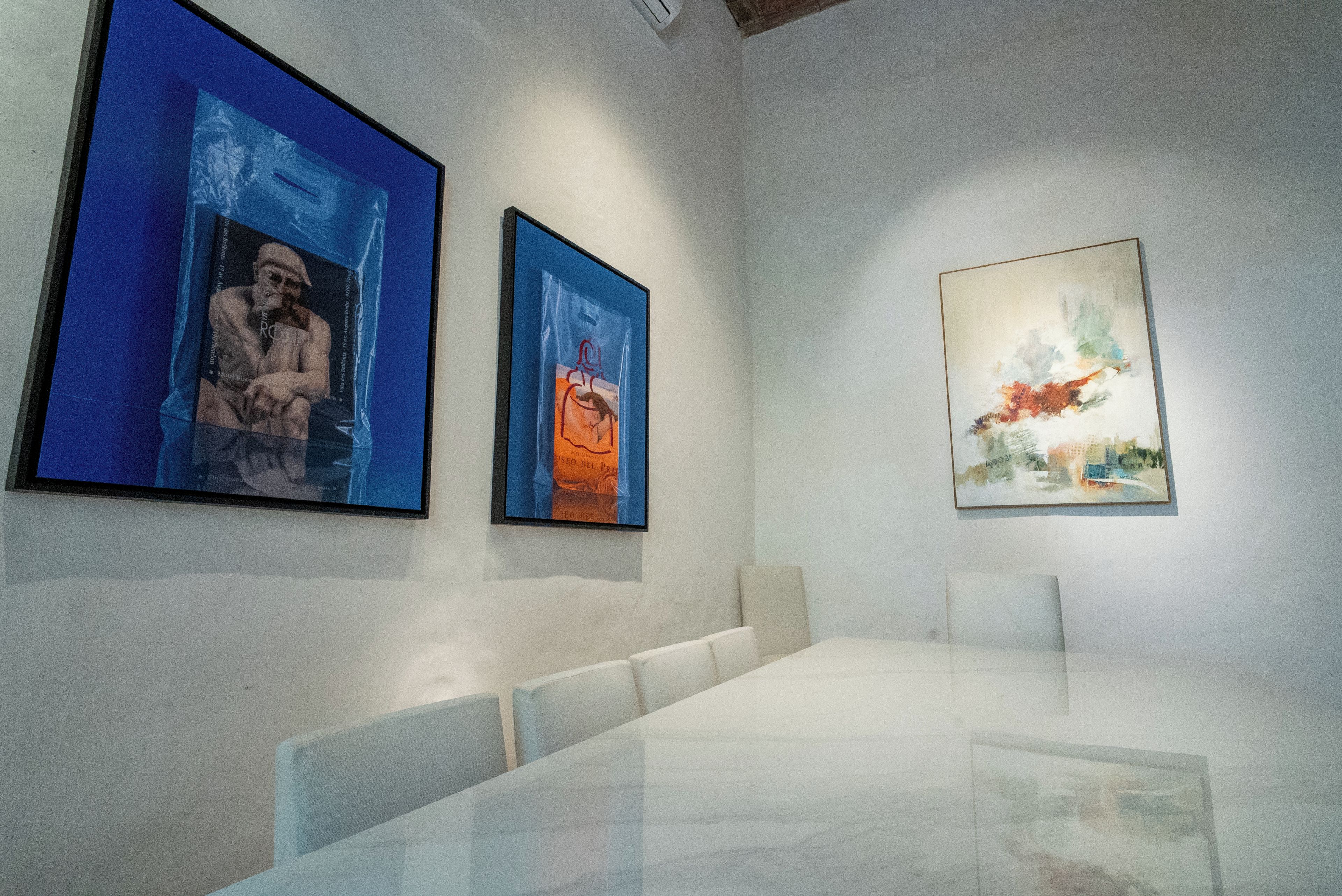 A gallery with three framed artworks on the wall.