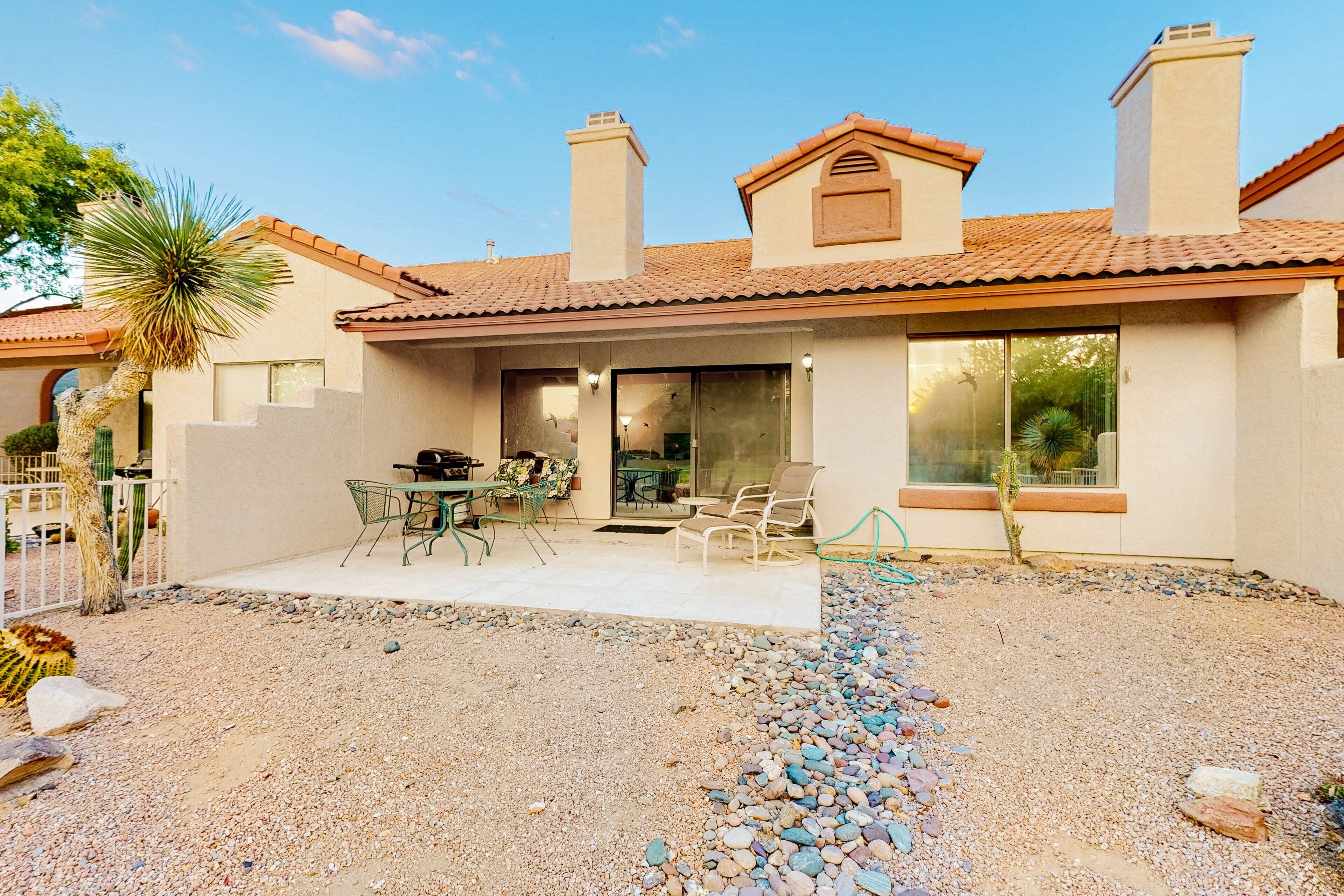 A house with a patio, outdoor seating, and a garden.