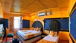 A wooden cabin-style room with two beds, a small kitchenette, and a ceiling with a honeycomb pattern. - Poets inn (Pahalgam)