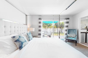 A bedroom with a large bed, a chair, and a view of the outdoors. - Newly-remodeled, family & dog-friendly house w/private pool spa & outdoor pool (Palm Springs)