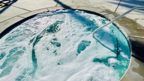 Ein kreisförmiger Pool mit einer zentralen Fontäne, umgeben von einer Betonplattform.