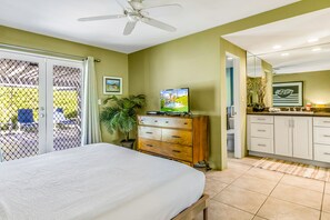 A bedroom with a bed, a TV, a wooden dresser, and a sliding glass door leading to a balcony. - Marvelous, Dog/Family-Friendly House w/Private Grill, Outdoor Pool, Attached Spa (Palm Springs)