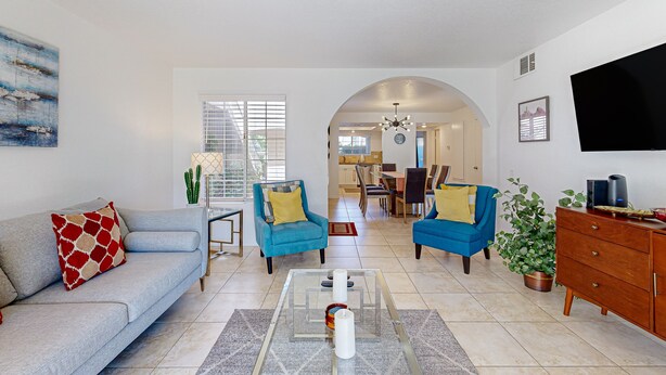 A modern living room with a sofa, two armchairs, a coffee table, and a TV. - Gated resort condo with outdoor pool, hot tub, & tennis - walk to dining (Palm Springs)