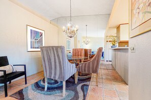 A dining area with a chandelier, striped chairs, and a patterned rug. - Inviting, dog-friendly condo with outdoor pool, pool spa & tennis access (Palm Springs)