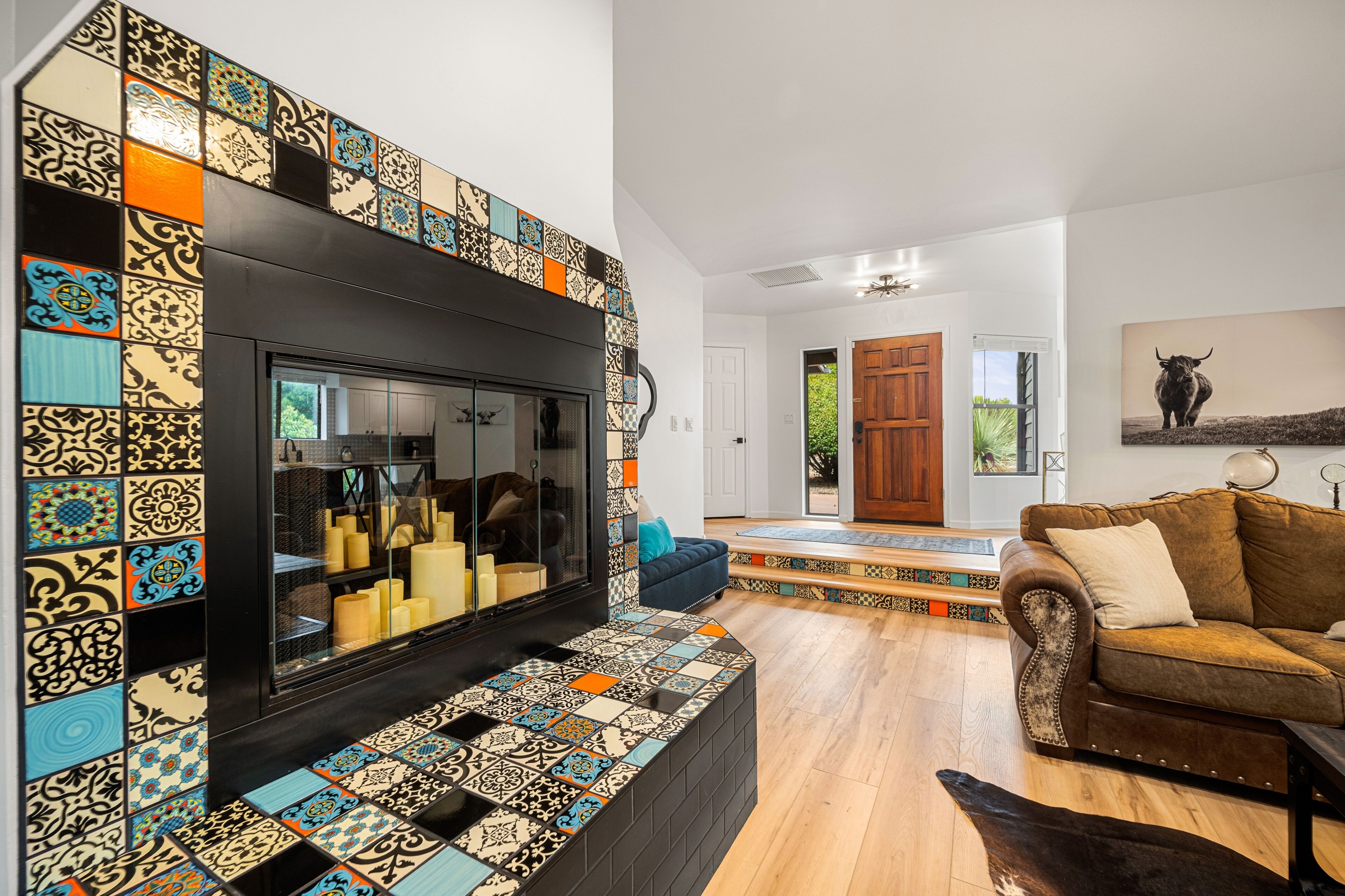 Una sala de estar con chimenea, baldosas estampadas, un sofá y una alfombra.