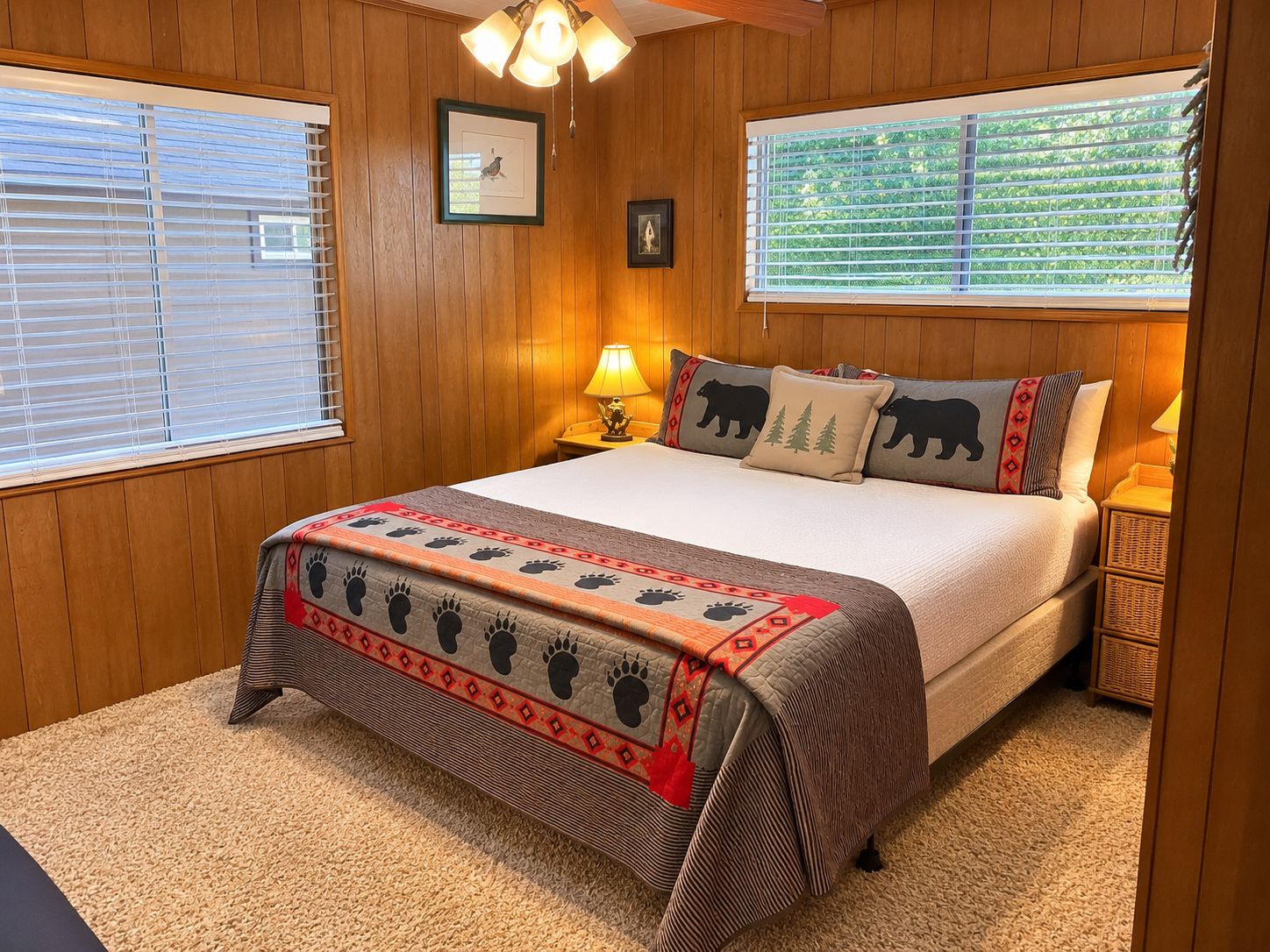 Een slaapkamer met een houten lambrisering, een bed met een witte dekbedovertrek, een decoratieve deken en twee bedlampjes.