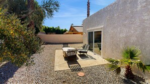 An outdoor patio with a table and chairs, surrounded by gravel and plants. - Recently Updated Home w/ Private Patios: 15 Mins From Downtown Palm Springs (Desert Hot Springs)