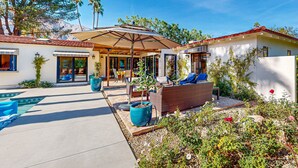 Eine Terrasse mit Sitzgelegenheiten, einem Pool und einem Garten.