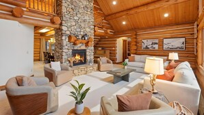 A log cabin interior with a stone fireplace, wooden beams, and a cozy seating area. - Heber Gathering Lodge, Game Room, Sleeps 32 (Heber City)