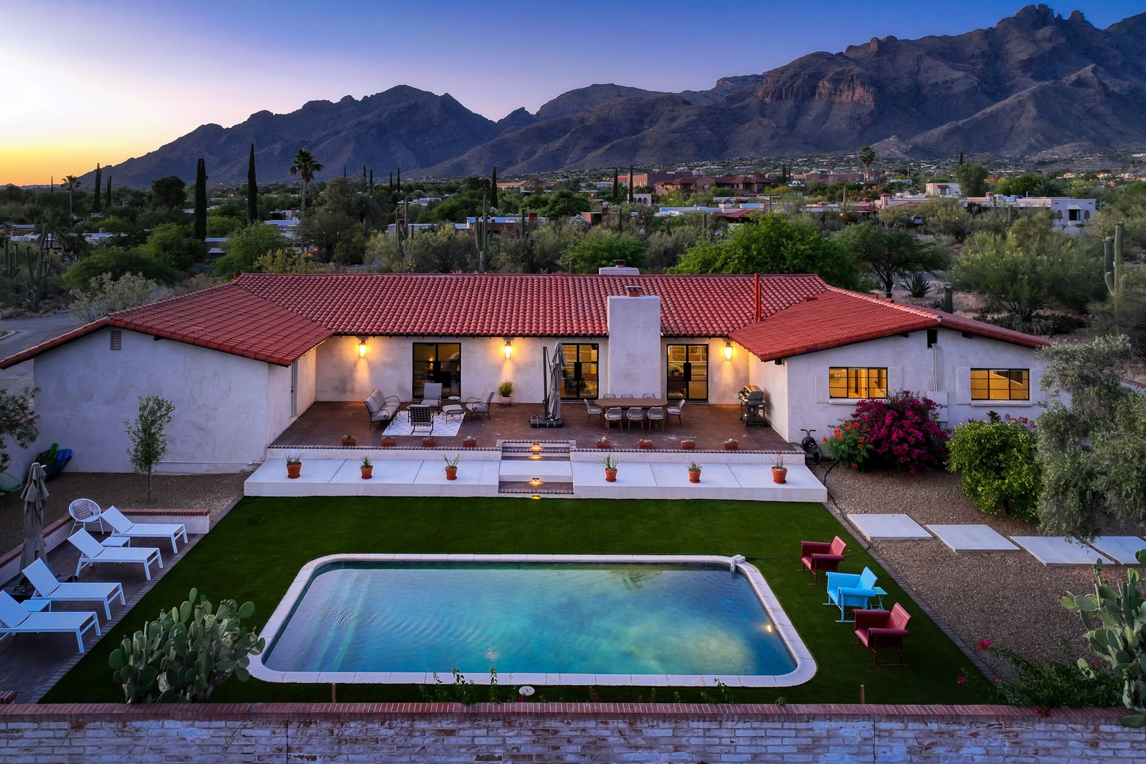 A large house with a swimming pool, patio, and mountain views.