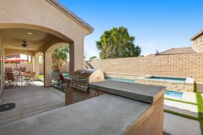 A patio with a grill, outdoor seating, and a swimming pool. - Inviting and unique dog-friendly home with pool, pool spa, firepit, & W/D (Indio)
