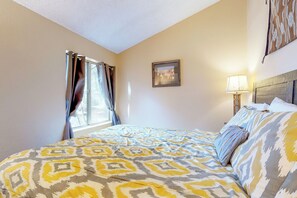 A hotel room with a bed, curtains, a framed picture, and a lamp. - Condo with full kitchen, balconies, views of Mt. Elden - close to town (Flagstaff)