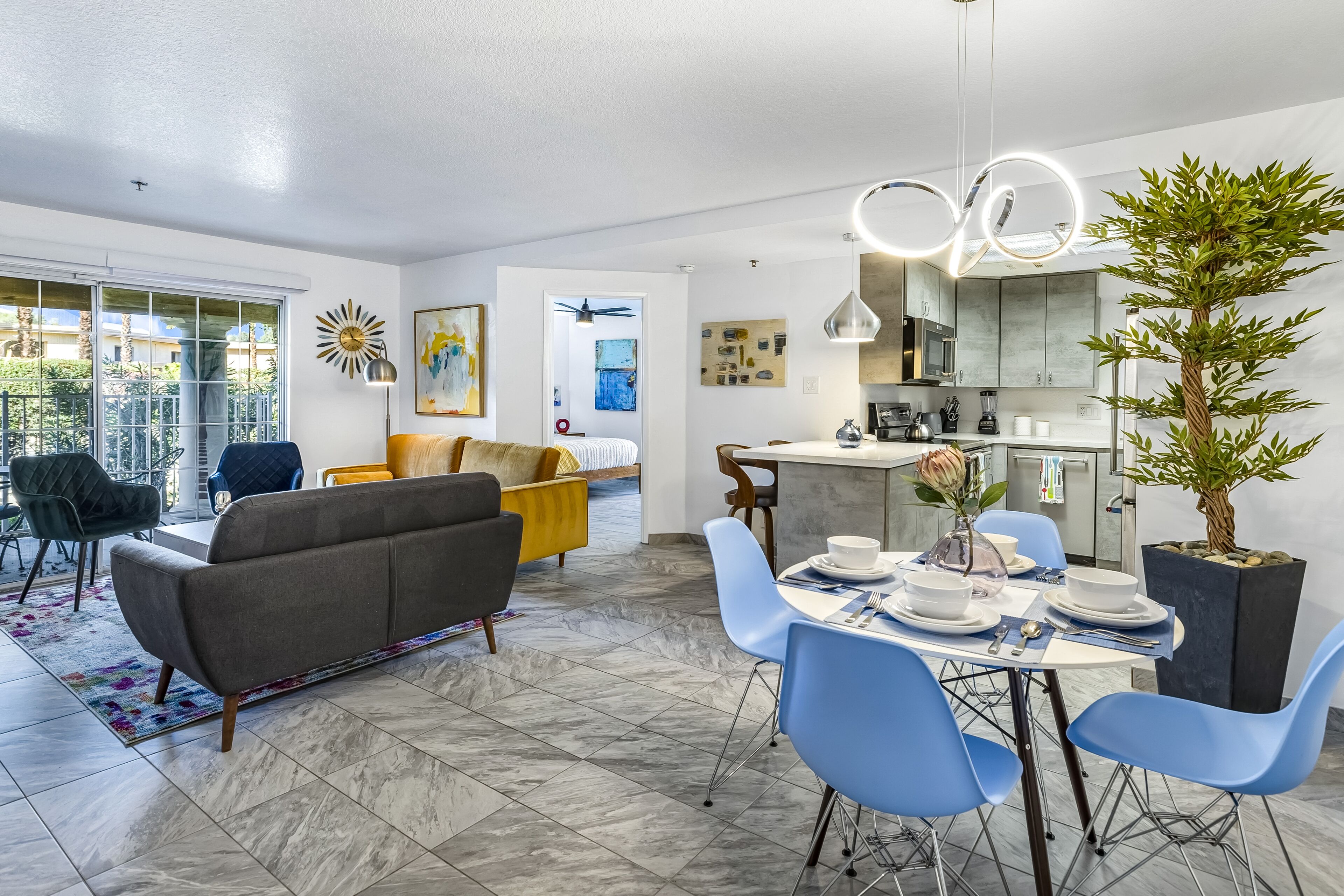 Un salon moderne avec un canapé, une table à manger et des chaises. Il y a également un coin cuisine avec une table à manger dressée pour le repas.