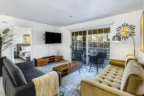 A modern living room with a sofa, armchair, and a coffee table. - Dog-friendly, ground-floor, mountain view condo with 2 patios, pool & hot tub (Palm Springs)