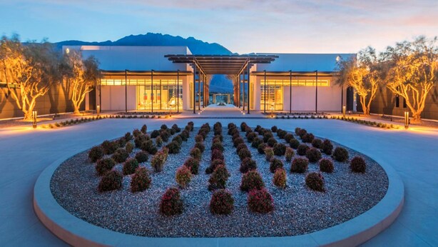 A modern building with a central entrance, surrounded by a landscaped garden with neatly arranged shrubs. - Chic dog-friendly home with private pool, pool spa, gym, pools, grills & firepit (Palm Springs)