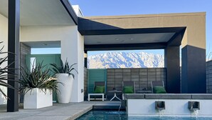 A modern outdoor pool area with a view of mountains, seating, and potted plants. - Chic dog-friendly home with private pool, pool spa, gym, pools, grills & firepit (Palm Springs)