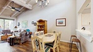 A dining area with a round wooden table, six chairs, and a wooden cabinet. - Beautiful Sedona townhome with pool, hot tub, tennis, & on-site golf (Sedona)
