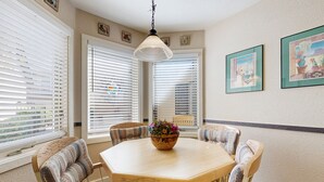 A dining area with a round table, six chairs, and a hanging light fixture. - Beautiful Sedona townhome with pool, hot tub, tennis, & on-site golf (Sedona)