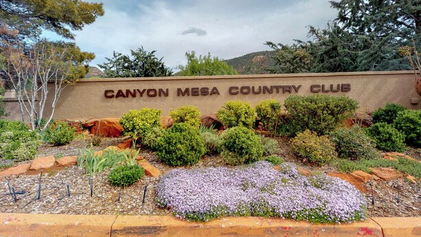 A sign for Canyon Mesa Country Club surrounded by landscaped gardens and trees. - Beautiful Sedona townhome with pool, hot tub, tennis, & on-site golf (Sedona)