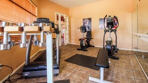 A gym with exercise equipment including treadmills, ellipticals, and a bench. - Bright & modern resort condo with pool & hot tub (Oro Valley)