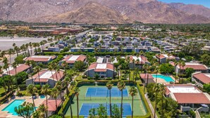 Zona residencial con varios edificios, cancha de tenis y piscina.