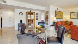 A modern living room with a glass dining table, leather chairs, a sofa, and a coffee table. - Dog-friendly condo w/ balcony & shared pools/hot tubs - close to downtown (Palm Springs)