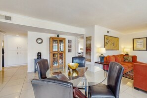 Ein modernes Wohnzimmer mit einem Glastisch, Ledersesseln, einer Couch und einem Couchtisch.