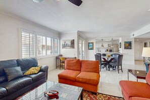 Ein Wohnzimmer mit einer Couch, einem Couchtisch und einem Essbereich mit Stühlen und einem Tisch.