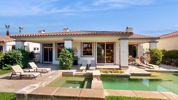 Une maison moderne dotée d’une piscine, d’un espace salon extérieur et d’un jardin bien entretenu.
