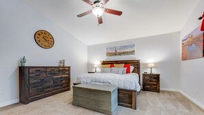 A bedroom with a bed, dresser, nightstands, a clock, and a ceiling fan. - Dreamy home with private pool, high-speed WiFi, full kitchen, & W/D (Sun City)