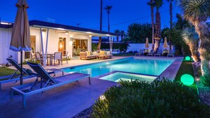 A modern house with a swimming pool, outdoor seating, and palm trees. - Cheerful mid-century home w/ private pool, spa, firepit & mountain views (Palm Springs)