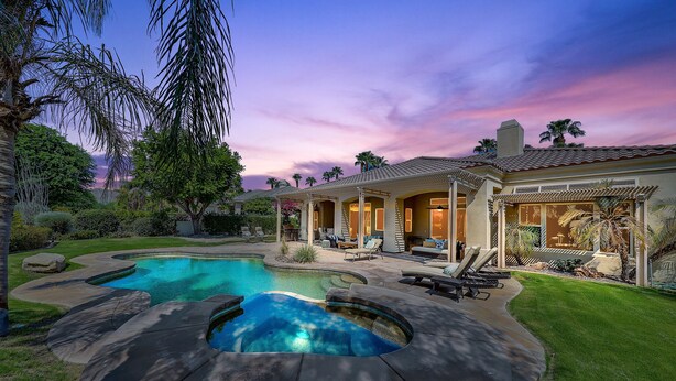 Propiedad residencial con piscina, jacuzzi y zona de estar al aire libre.
