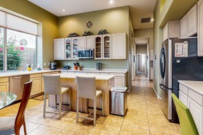 A modern kitchen with a central island, white cabinetry, and stainless steel appliances. - Dog-friendly home w/outdoor pool & firepit, near the top of South Mountain - Desert Foothills (Phoenix)