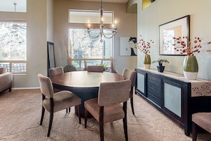 A dining area with a round table, six chairs, a chandelier, and a view of a mountainous landscape through large windows. - Dog-friendly home w/outdoor pool & firepit, near the top of South Mountain (Phoenix)
