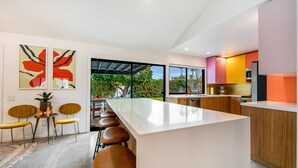 Cozinha moderna com ilha central, armários de madeira e uma janela ampla.