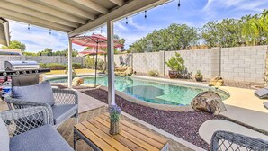 A covered patio area with a pool, outdoor furniture, and a barbecue grill. - Single-level dog-friendly home with private pool, grill, enclosed backyard, & AC (Chandler)