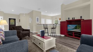 A living room with a TV, two chairs, a sofa, and a small table. - Gorgeous Executive Disney Pool Home in High Grove Clermont 4BR/ 3BA (Clermont)