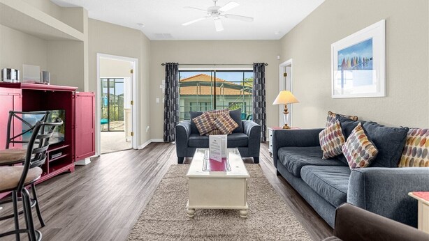 A living room with a sofa, chairs, a coffee table, and a TV stand. - Gorgeous Executive Disney Pool Home in High Grove Clermont 4BR/ 3BA (Clermont)