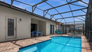 An indoor swimming pool with clear blue water, surrounded by a glass enclosure and a tiled deck. - Gorgeous Executive Disney Pool Home in High Grove Clermont 4BR/ 3BA (Clermont)