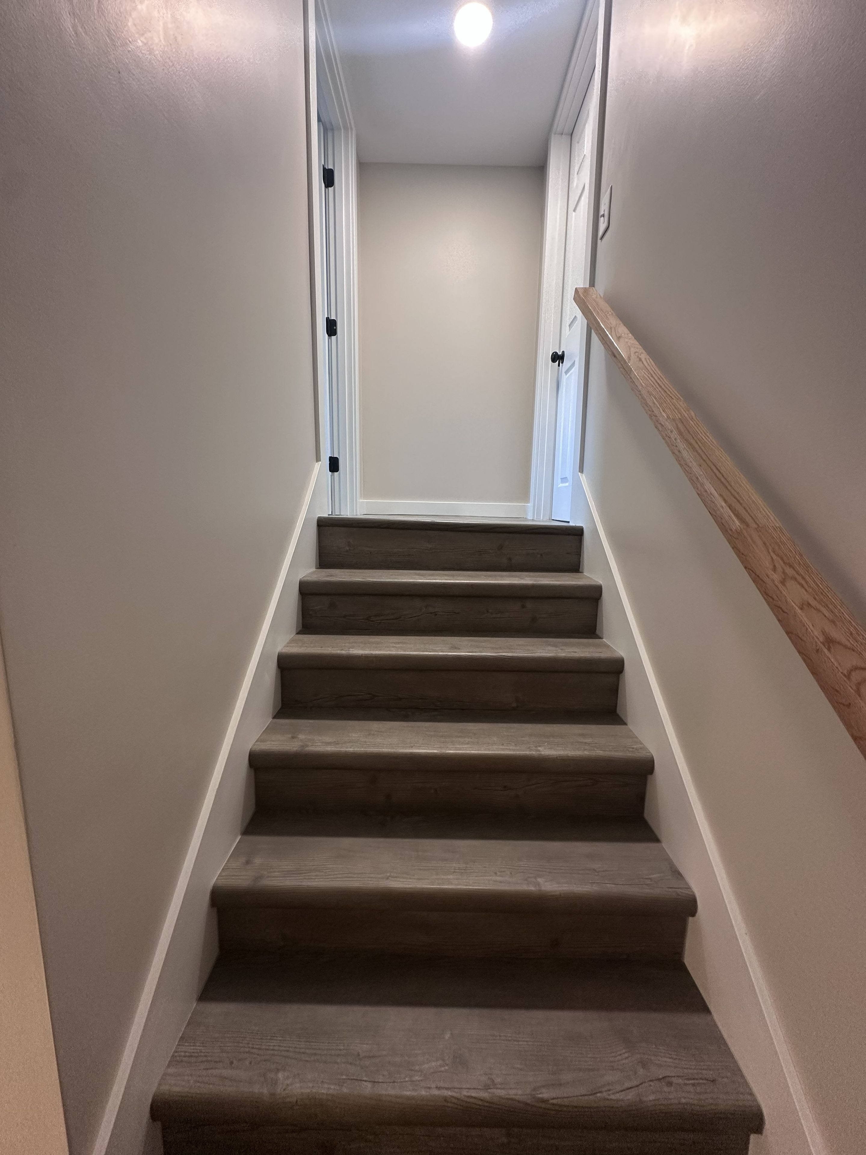A staircase with wooden steps and white walls.