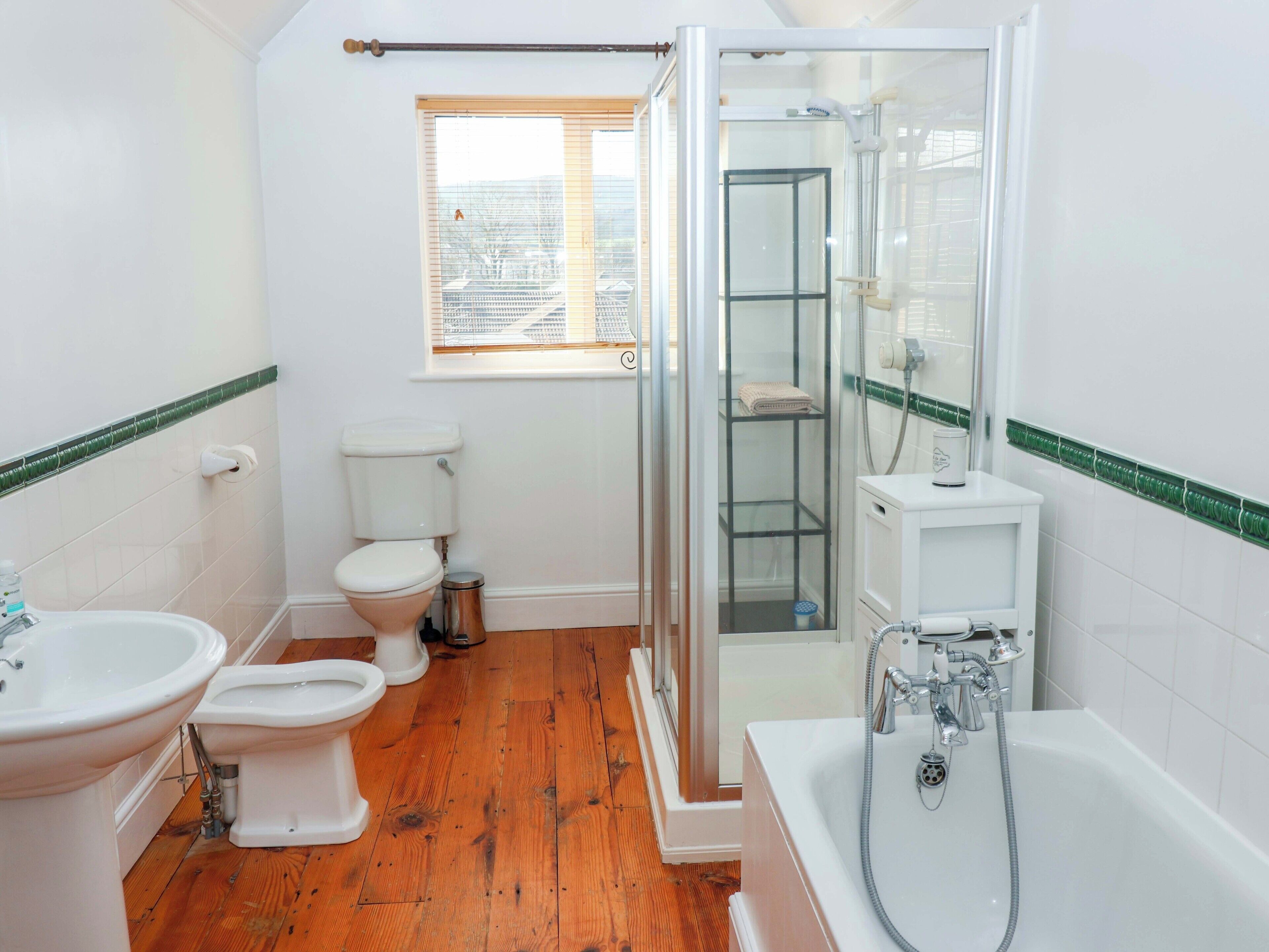 A bathroom with a toilet, bidet, sink, and bathtub.