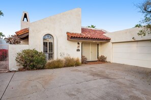 A residential property with a garage, a driveway, and a small garden area.