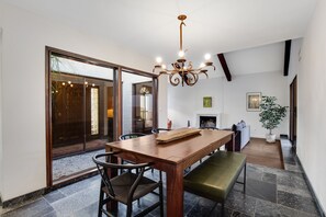 Ein Essbereich mit Holztisch, Stühlen, einer Bank und einer Chandelüstere.