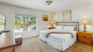 A bedroom with a bed, bedside tables, a desk, a window with blinds, and artwork on the wall. - Luxurious home with an outdoor kitchen, private pool & spa - close to golf (Bermuda Dunes)