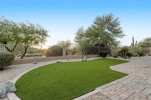 A landscaped garden with a paved walkway, a fenced area, and various shrubs and trees. - Stunning home with mountain views, pool, fast WiFi, central AC & W/D (Mesa)